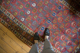 Antique Northwest Persian rug's raspberry red field, sky blue lattice, and germinating plant motifs.