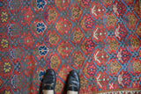 Antique Northwest Persian rug's repeating germinating plant motifs in raspberry, sky blue, and gold.