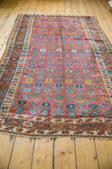 Antique Northwest Persian rug close-up: fringe, patterned border, and visible localized pile wear.