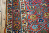 Antique Northwest Persian rug featuring germinating plant motifs within blue lattice, detailed floral border.