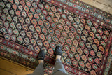 Antique Kurdish runner's staggered boteh pattern, showcasing blush, sky blue, saffron, and charcoal hues.