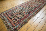 Antique Kurdish runner, staggered boteh pattern in blush, saffron, sky blue on dark ground.