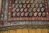 Detail of the antique Kurdish runner's multiple patterned borders and soft fringe.