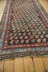 Soft fringe and intricate lower border of the antique Kurdish runner, displaying blush, ivory, and blue motifs.