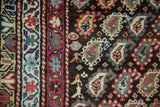 Antique Kurdish runner's hand-knotted pile, charcoal black field, red, ivory, sky blue boteh, geometric border.