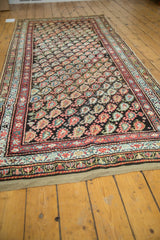 Antique Kurdish rug runner corner displaying red, ivory, and sky blue floral border patterns.