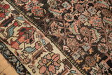 Kurdish Bijar rug's wide antique ivory border with floral elements and dark herati field.