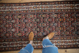 Vintage Malayer runner's chocolate brown field with germinating flower motif and ivory border.