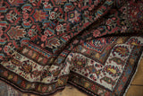 Close-up of Malayer runner's border, displaying cream ground with red, blue, and gold patterns.