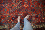 Distressed Joshegan carpet, black cherry red with sapphire blue and ivory floral lattice pattern.