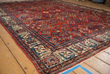 Black cherry red field and ivory-blue patterned border of distressed Joshegan carpet.