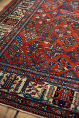 Joshegan carpet border and red field with sapphire blue and ivory floral designs, subtly worn pile.