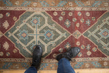 Distressed hand knotted Malayer runner's worn pile and geometric patterns in seafoam green and wine red.