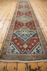 Geometric border and aged field motifs on the antique Malayer runner in wine red and dusty green.