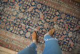 Persian Malayer runner's allover henna plant motif in navy, terracotta, and sand, showing even wear.