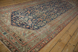 Vintage Malayer runner's terracotta geometric border and navy field with henna motif.