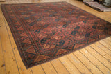 Vintage Ersari carpet with repeating floral medallions and concentric zigzag border.