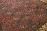 Vintage Ersari carpet detail: red-rust field, mallard green medallions, germinating plants, visible wear.