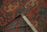 Ersari rug folded corner with chestnut, mallard green floral medallions and zigzag border, showing wear.