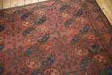 Repeating floral medallions, germinating plants, and zigzag border on vintage Ersari carpet.