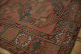 Antique Ersari rug's brick red and navy gul motifs with low pile texture.