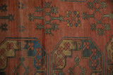 Repeating gul motif of an antique Ersari carpet in dark brick red, navy, and gem green.