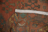 Folded antique Ersari carpet corner showing brick red guls, pile wear, faint foundation, and secured edge.