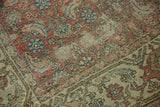 Distressed Hamadan rug close-up showing Herati motif, chestnut brown, antique ivory, and threadbare areas.