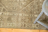 Distressed Shiraz rug border with intricate hook-and-latch motifs and aged pile.