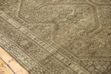 Distressed vintage Shiraz rug's even wear revealing intricate slate and ivory motifs.