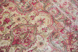 Distressed vintage Meshed rug texture with raspberry, pink, ivory scrolling floral patterns.