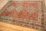 Distressed light blue diamond medallion and geometric borders of a vintage Qashqai carpet.