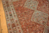 Distressed pile on the vintage Qashqai carpet, featuring a patterned border and faint animal motifs.