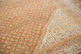 Distressed burnt orange field with diminutive botehs and intricate ivory, powder blue border.
