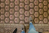 Distressed Khotan rug, faded pink floral bouquets, and undulating Samarkand style border.