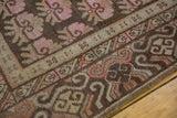 Vintage Distressed Khotan rug corner with undulating brown and pink border, revealing distressed low pile.