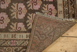 Distressed pink floral pile and intricate hand-knotted foundation of the vintage Khotan rug.