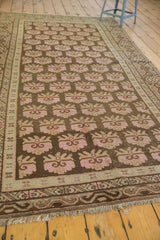Charcoal brown distressed Khotan rug detail, faded pink floral bouquets, and wavy border.
