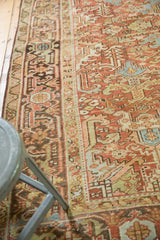 Distressed vintage Heriz carpet with softened brick red, powder blue, celadon geometric patterns and even wear.