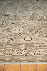 Distressed vintage Malayer carpet with neutral floral motifs, pale blue, and worn pile texture.