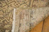Distressed Heriz carpet back, fringe, and primitive geometric motifs in ivory and brown.
