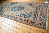 Vintage Khotan carpet displays navy blue medallion, trefoil finials, and delicate trellis field.