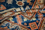 Navy blue and dusty tangerine trefoil motifs with antique ivory and brown tones on vintage Khotan pile.