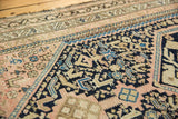 Intricate navy and blush geometric patterns on a time-softened vintage Persian Hamadan rug.
