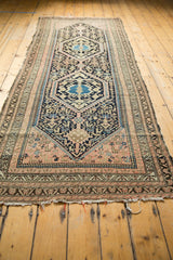 Tattered fringe and geometric patterned border of the vintage Hamadan rug in navy, blush, and sand.