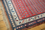 Secure macrame fringe and intricate madder red, navy, ivory geometric borders.