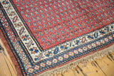 Kurdish carpet corner with madder red diminutive boteh, navy and ivory borders, intact fringe.