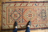Antique Moghan Kazak runner featuring geometric gul medallions and rich, aged Caucasian dyes.