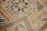 Antique Moghan Kazak runner detail: visible hard wear to foundation, tattered fringe, geometric patterns.