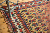 Antique Caucasian rug edge showing tattered ends, bold geometric borders, and gold ground guls.